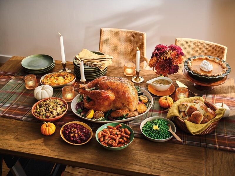 Thanksgiving table with a roast turkey and side dishes