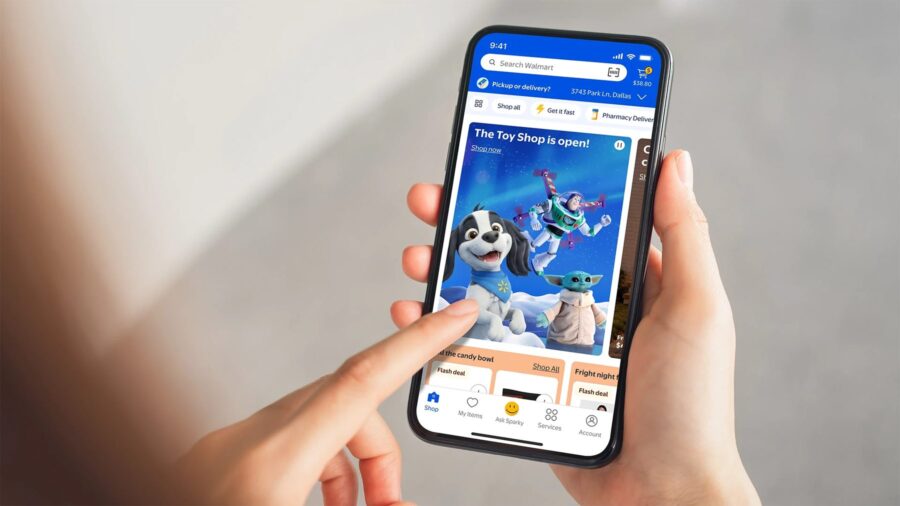 A hand holding a phone with the Walmart app open on a holiday toy shop
